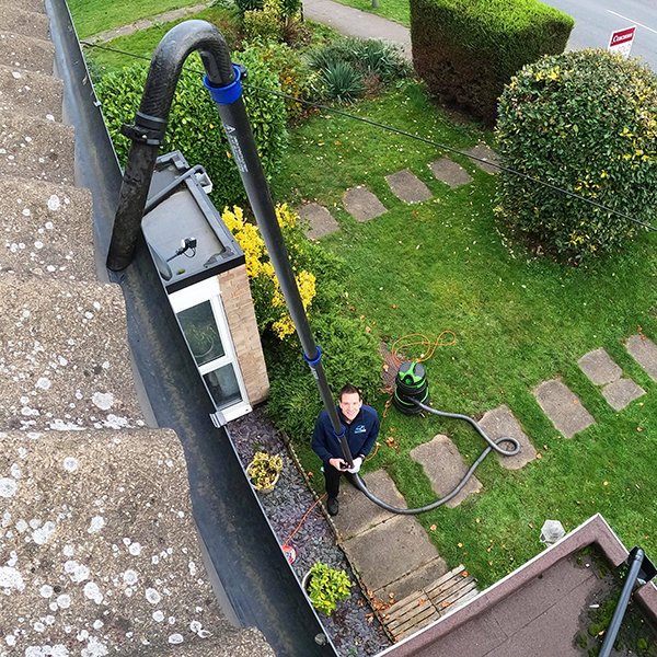 Gutter clearing in Great Bookham – removing packed oak leaves and acorns from a blocked gutter outlet
